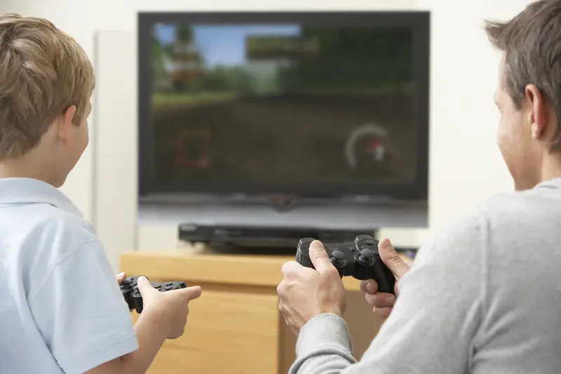 A parent and child enjoy playing a video game together while on vacation.